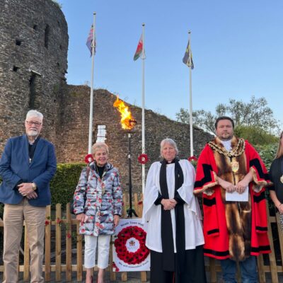 Cllr. Bob Price, Cllr. Mrs Sara Price, Canon Kynda Newman, Cllr. Paul James in robes and Mayoral Chain outside Neath Castle adn the Beacon lit behind